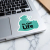 Turquoise sticker with "St. Clair Life" text and a map shape on a laptop.