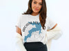 White t-shirt with blue Arcadia Lake map graphic and compass rose.