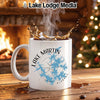 White mug with Lake Martin Alabama design and splash of coffee.