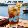 Glass with Hayden Lake map and compass, garnished with lemon, on wooden table.