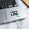 Sticker with teal lake shape and black text "Long Life" on laptop.