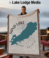 Sand Lake Ontario map blanket with compass rose design held by a man.