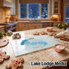 A glass cutting board featuring a blue map of Forest Lake, Minnesota, surrounded by holiday baking supplies on a kitchen counter.