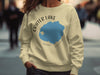 Crater Lake Oregon graphic on tan crewneck sweatshirt worn by a person.