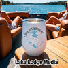 A white insulated wine tumbler with a Lake Disharoon Georgia compass design sits on a wooden boat table.