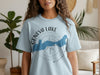 Light blue t-shirt with Geneva Lake, Wisconsin map and compass design.