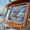 Key Largo Life sticker on a wooden boat window with Lake Lodge Media logo.