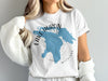 White t-shirt with blue Lake Huron map and compass design.