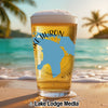 Glass of beer with Lake Huron map and text, on a beach.