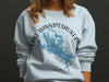 Light blue sweatshirt with Lake Winnipesaukee map and compass design.