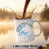 White mug with "Green River Lake Kentucky" and compass design, coffee pouring in.