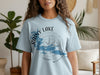 Light blue t-shirt featuring a compass graphic with "Rainy Lake" and "Minnesota" text.
