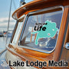 Teal Simcoe Life sticker on a wooden boat window with Lake Lodge Media text.