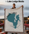 Man holding a Sebago Lake Maine map blanket with fringe.