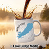 White mug with Sand Lake Ontario map and compass design, pouring coffee.