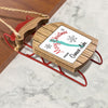 Wooden sled ornament with text "Merry Christmas From Owasco Lake" and snowflakes.