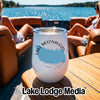 A white stemless wine tumbler with Lake McConaughey graphics sits on a boat table.