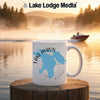 White mug with Lake Huron map and compass on wooden stump against foggy lake sunrise.