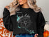 Black sweatshirt with a "Beautiful Highland Lakes Texas" map and compass graphic.