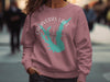 Pink sweatshirt with turquoise Calaveras Lake Texas map and compass graphic.
