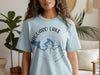 Light blue t-shirt with Saguaro Lake Arizona map graphic and compass design.