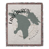Woven blanket with Lake Huron map and compass design.
