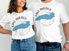 White t-shirts featuring "Lake America" text, blue map outline, and compass design.