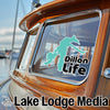 Turquoise "Dillon Life" sticker on a boat window with "Lake Lodge Media" text below.