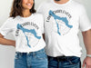 White t-shirts display "Lake Charlevoix Michigan" with a blue lake map and compass.