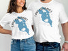 Two people wear white t-shirts with a blue map of Lake Kissimmee and a compass.