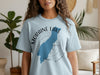 Light blue t-shirt with Moraine Lake outline and compass design in Alberta, Canada.