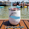 A white tumbler with an Oneida Lake map graphic resting on a wooden boat deck.