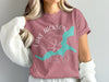 Dusty rose t-shirt with "Lake Jackson Georgia" text and a teal map outline over compass graphic.