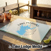 Glass cutting board featuring a Lake Pleasant, Arizona map graphic resting on a wooden table outdoors.