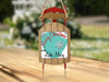 Wooden sled ornament with "Merry Christmas FROM Lake Mary" and snowflakes.