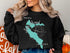 Black sweatshirt with Lake Merced California map and compass graphic.