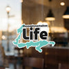 Ossawinamakee Life sticker with teal outline of a state and bold black text.