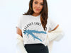 White t-shirt with a blue map of Fellows Lake, Missouri and compass design.