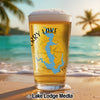 Beer glass with blue lake map and compass, beach background.