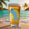 Beer glass with Jordan Pond map and "Maine" text on a beach at sunset.