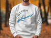 White sweatshirt with Lake Icara Iowa map and compass design.