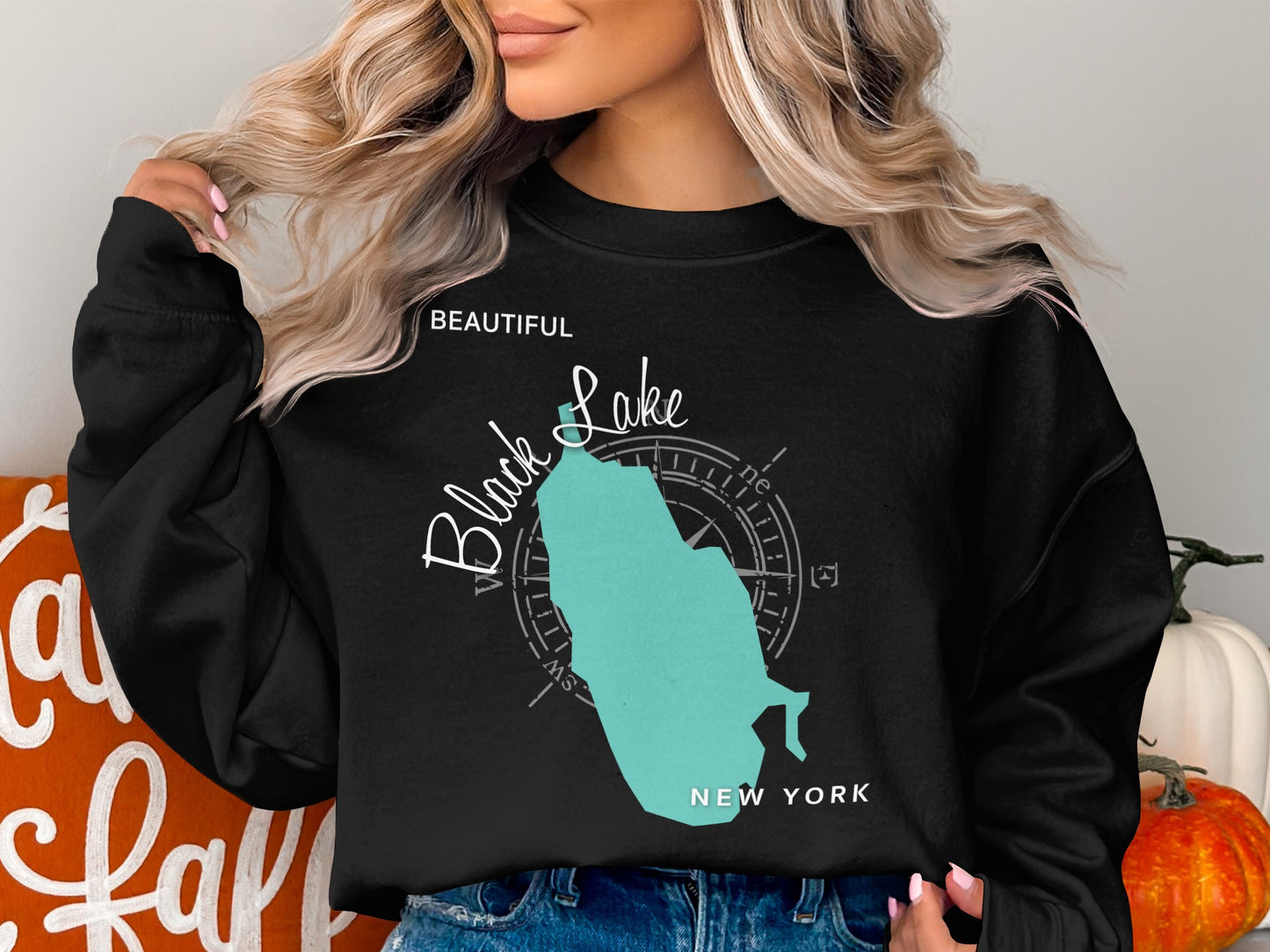 Black sweatshirt with a teal map of New York and compass rose.