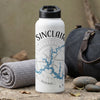 White water bottle with "SINCLAIR" and nautical compass design beside a rolled towel.