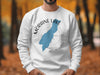 White sweatshirt with Moraine Lake shape and compass graphic, Alberta.