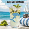 Glass with drink, limes, mint, and California map design on beach background.