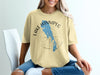 Light yellow t-shirt with Lake Winnipeg map, compass, and "Manitoba" text.