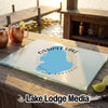 A glass cutting board featuring a blue map of Ossipeet Lake, New Hampshire, rests on a wooden outdoor bar.