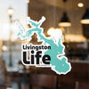 Livingston Life sticker on a window with a teal lake outline.