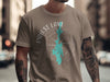 Taupe t-shirt with white Priest Lake Idaho text and teal lake outline.