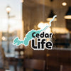 Sticker with teal outline of a lake, saying "Cedar Life" and "Lake Lodge Media LLC".